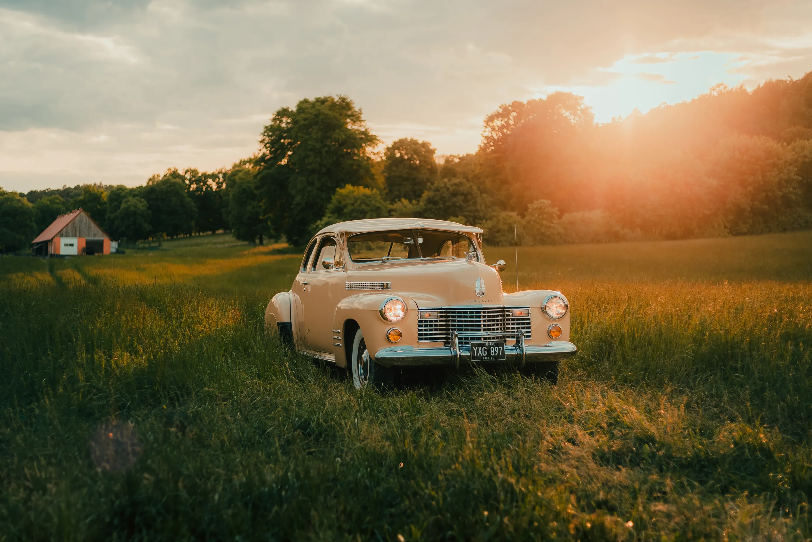 Cadillac Series 62 Coupe z 1941 roku na łące o zachodzie słońca